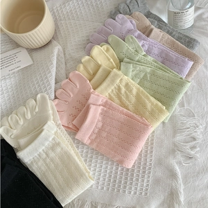 Detail of five-toe mesh socks in various pastel colors on a soft fabric background