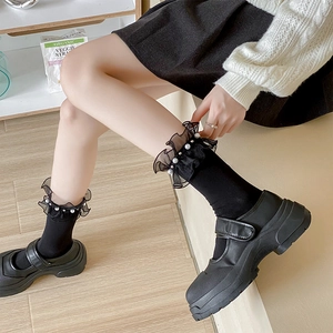 Detail of black Lolita mid-calf socks with lace ruffles and white pearl embellishments