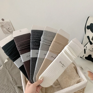 Detailed view of six solid color cotton blend socks with fine ribbed textures and labels