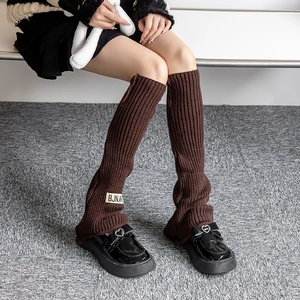 Retro dark brown knitted leg warmers with vertical ribs and vintage label detail