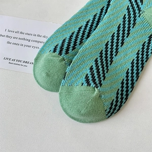 Detailed close-up of green and black diagonal knit pattern on cotton blend crew socks