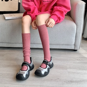 Detalle de calcetines rosa acanalados con zapatos Mary Jane en plata y negro metalizado