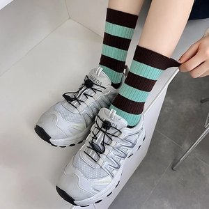 Vintage striped crew socks in brown tones paired with mesh athletic sneakers