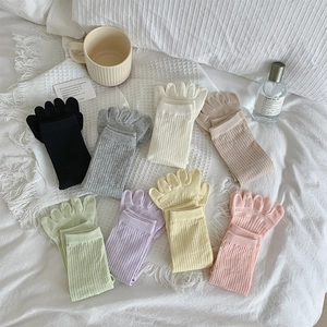 Flachbild von bunten Fünf-Finger-Socken in acht Bonbonfarben auf weißem Hintergrund