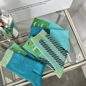 Macro detail of teal and navy patterned cotton socks with stylish diagonal stripe design