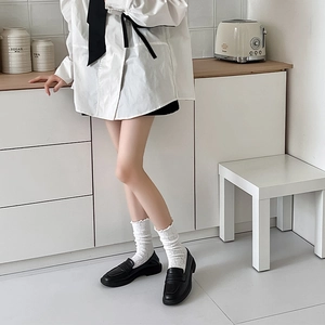 Vue détaillée de mocassins noirs avec chaussettes blanches en dentelle ajourée