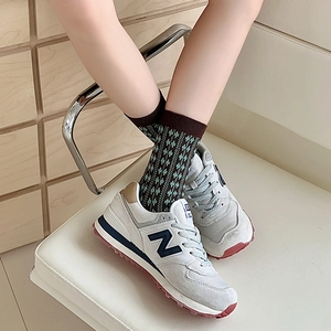 Detail view of vintage brown striped socks paired with classic white retro sneakers