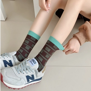 Detail of vintage brown plaid knit socks with mint green ribbed cuffs on feet