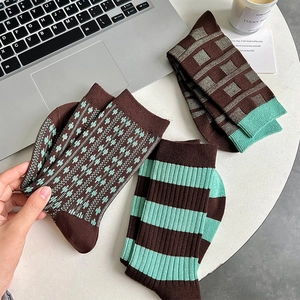 Detailed knit texture of vintage brown and mint green striped crew socks in 3-pack set