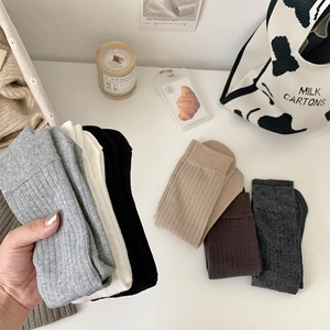 Close-up of ribbed knit texture on colorful crew socks in various neutral tones