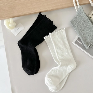 Chaussettes noires et blanches avec bordure à volants et texture en maille torsadée