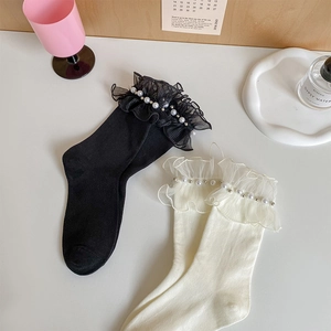 Detail of ruffled lace socks with pearl beads in black and white French vintage style