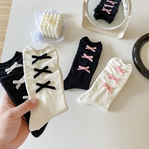 Détail de nœuds en velours sur chaussettes côtelées en coton mélangé de différentes couleurs