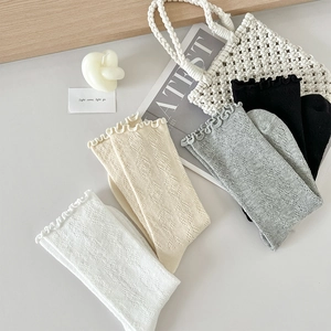 Détail du motif en tricot ajouré et des bords à volants sur le lot de chaussettes
