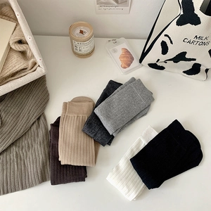 Detailed knit texture of rib-cuffed cotton crew socks in six earth-toned colors