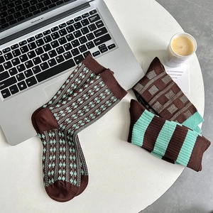 Flat lay of vintage brown and green checkered crew socks with tight knit texture
