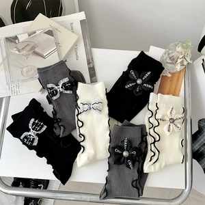 Detail of cotton crew socks with frilly edges and delicate bow flower decorations