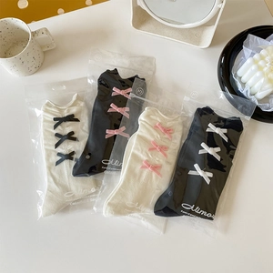 Vue détaillée de quatre paires de chaussettes à nœuds douces en blanc et noir emballées