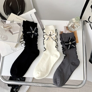 Detailed knit cotton socks featuring lettuce trim cuffs and fabric flower accents in three colors