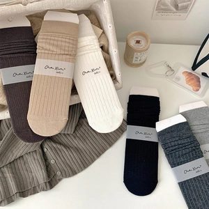 Detail of solid color ribbed cotton mid-calf socks in a warm neutral earth tone collection
