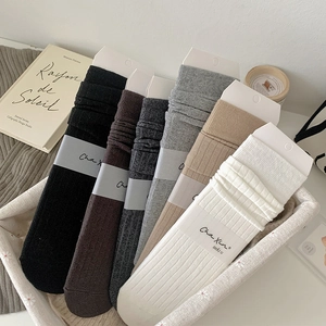 Detail of six-color ribbed cotton crew socks in neutral tones with brand packaging labels