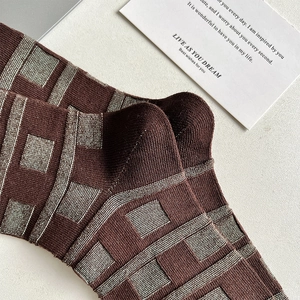 Detailed close-up of brown geometric plaid knitted crew socks with soft cotton texture