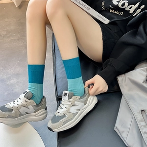Contrast blue knit crew socks paired with gray mesh sneakers for a stylish sporty look