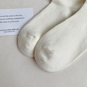 Primer plano de calcetines de algodón de canalé blanco crema con costuras detalladas