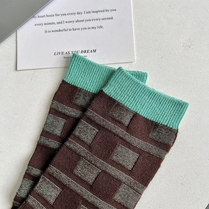 Close-up of brown checkered cotton crew socks with mint green ribbed cuffs detail