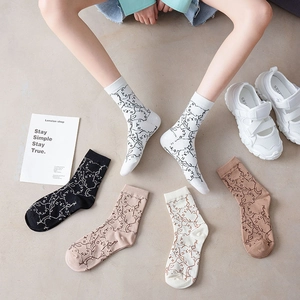 Detail of cartoon cat pattern on cotton crew socks in multiple colors with white sneakers