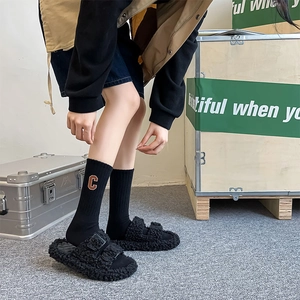 Detail of embroidered C letter on black cotton socks with stylish plush double buckle slides