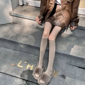 Détail de chaussettes hautes en maille côtelée kaki avec des chaussons en fausse fourrure