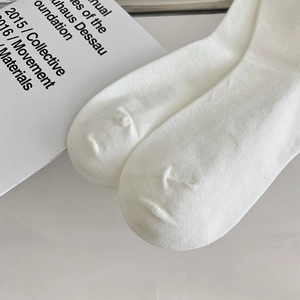 Gros plan détaillé de chaussettes blanches en coton tricoté montrant le tissage fin