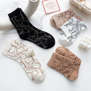 Flat lay of cotton socks featuring minimalist cat patterns in various earthy tones