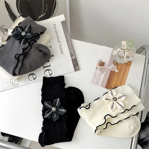 Three pairs of ribbed knit crew socks with vintage bows and ruffled edges displayed