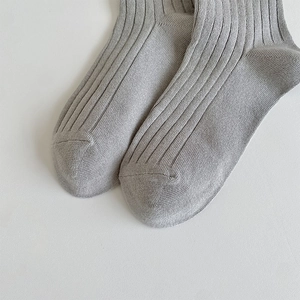 Macro view of grey ribbed over-knee socks highlighting cotton texture and reinforced toe seam