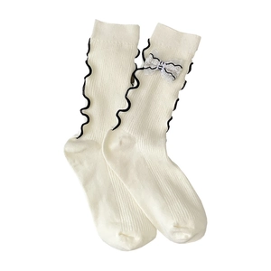Elegant cream socks with black wavy ruffles and white lace bow detail for women