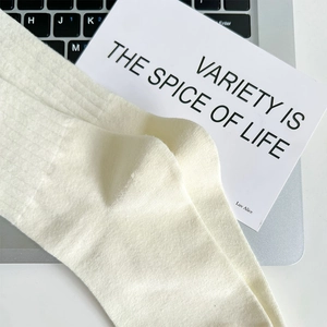 Detailed knit texture of off-white mid-calf socks laid over a laptop keyboard