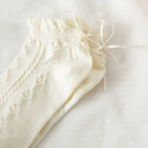 Primo piano di calzini in pizzo a maglia con fiocchi eleganti e motivi a rombi