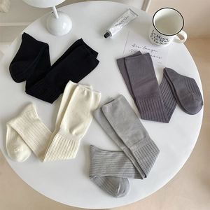 Vertical ribbed texture detail of cotton over-the-knee socks in neutral color palette