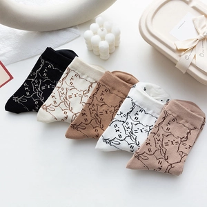 Detail of five pairs of cotton crew socks with minimalist cat prints in earthy tones