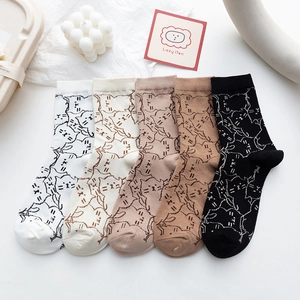 Close-up of five pairs of cotton socks with minimalist cat illustrations in neutral tones