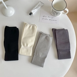 Detailed view of knitted over-knee socks in four colors with ribbed cuffs texture