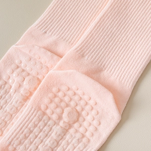 Gros plan de chaussettes de yoga roses avec picots antidérapants et lettrage SOCKS