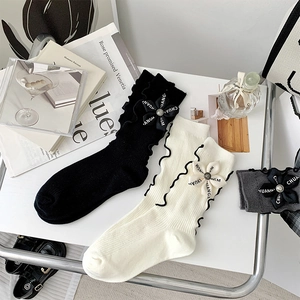 Detailed knit socks with ruffled edges and 3D floral accents in black, white, and grey