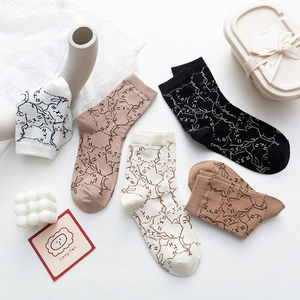 Flat lay of cotton socks featuring cartoon cat patterns in black, white and khaki tones