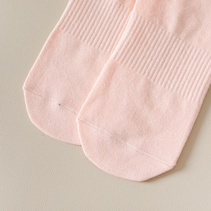 Gros plan de chaussettes de yoga roses montrant la maille côtelée et la couture aux orteils