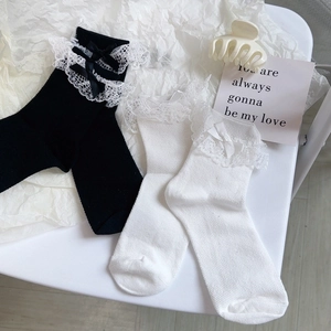 Saussettes Lolita avec dentelle et nœuds papillon en noir et blanc présentées à plat