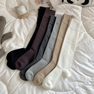 Vue détaillée de six couleurs de chaussettes hautes côtelées en coton sur une couette