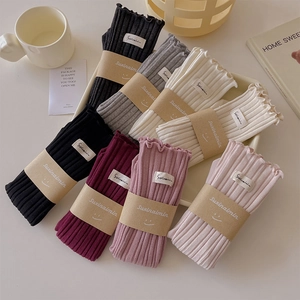 Row of colorful ribbed knit socks featuring delicate ruffle edges and brand labels